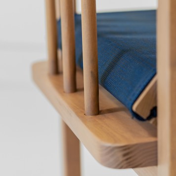 Photo zoomée des barreaux latéraux d'une chaise directeur en bois