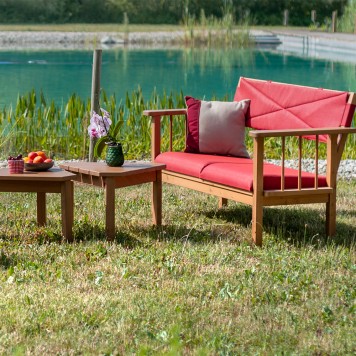 banquette en bois et tissu rouge + 2 table basse en bois au bord d'un lac.